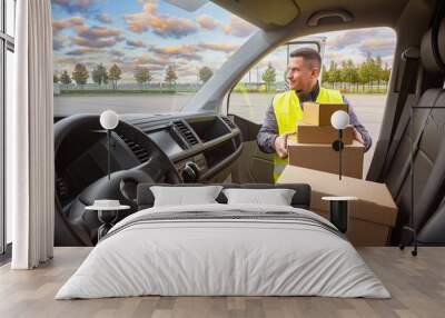 Delivery of parcels. Satisfied man at work. Concept of transportation and logistics services. The driver chooses the route of cargo. Forwarder booted in stock. Wall mural