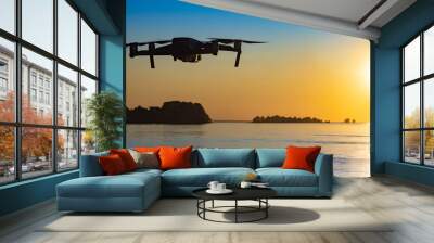 Drone flight at sunset. The quadcopter flies over the water against the backdrop of the setting sun. Panorama of the lake at sunset. The drone takes beautiful pictures. Hobby - manage quadcopter. Wall mural