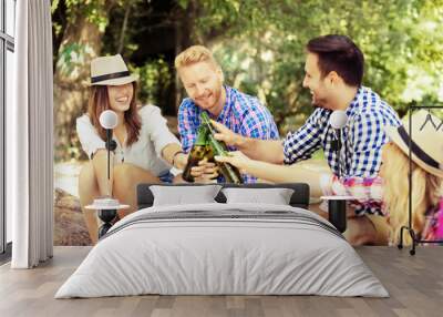 Friends enjoying camping and grilling sausages. Wall mural