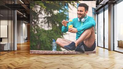 Man is eating fruit after morning workout Wall mural