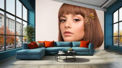 Face close up. Portrait of a woman with a bob haircut. In her hair there is a hairpin with large crystals. Makeup, black arrows and pearlescent brown shadows. Wall mural