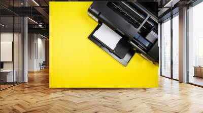 Top view of a photo printer and a blank sheet of photo paper on a yellow background Wall mural