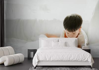 3 years old asian boy is drawing a picture of his cat in living room Wall mural