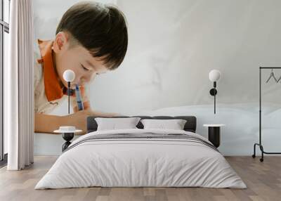 3 years old asian boy is drawing a picture of his cat in living room Wall mural