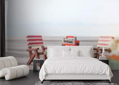 Miniature radio on a table and beach chair with sea background. Wall mural