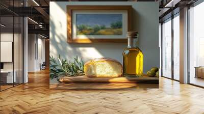 Olive oil, bread, and fresh olive branches on a table, with a rectangular painting framed on the white wall behind. Wall mural