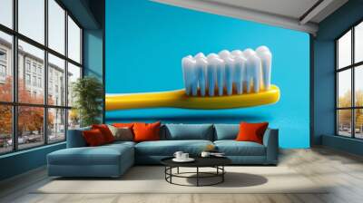 Yellow toothbrush with toothpaste close-up on a blue background, highlighting dental care with room for text. Wall mural