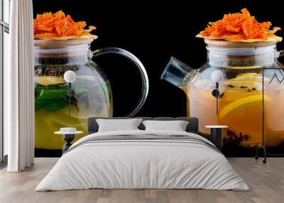 Hot tea with lemon, mint and sea buckthorn. In a glass teapot on a dark background. With pumpkin chips Wall mural