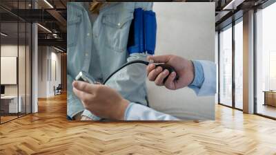 Close-up of Doctor hand measuring blood pressure of woman patient Wall mural