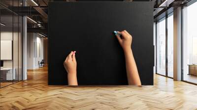 Image of little boy,s hands drawing picuters on the black chalk board. Chalk board background. Wall mural