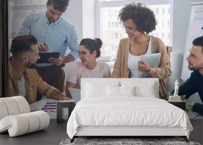 Group of confident young people in smart casual wear discussing business while having meeting in office Wall mural