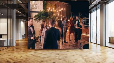 Group of people in formalwear communicating and smiling while spending time on luxury party Wall mural