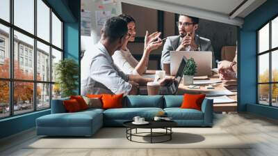 Group of young people discussing business while having meeting in the office Wall mural