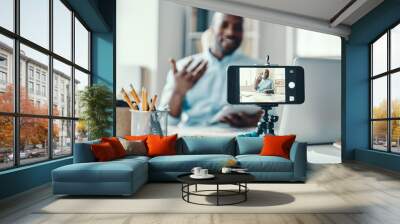 Handsome young African man in shirt telling something and smiling while making social media video Wall mural