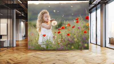 A little girl with a dandelion on a summer meadow Wall mural