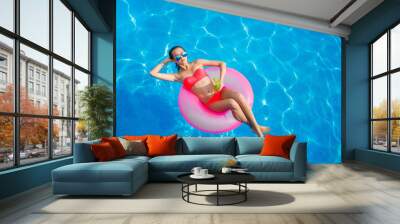 Beautiful girl in the pool on inflatable lifebuoy Wall mural