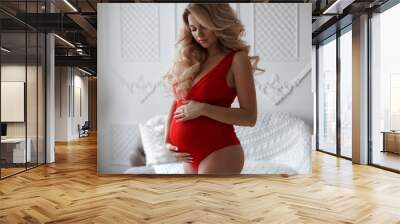 Pregnant woman feeling happy while taking care of her child. The young expecting mother holding baby in pregnant belly. Maternity prenatal care and woman pregnant health care concept.Beautiful pregnan Wall mural