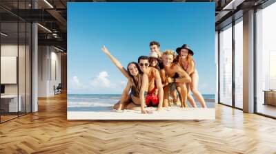 Happy group of young friends at the beach Wall mural