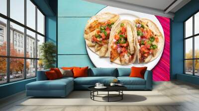 Mexican fish tacos also called Baja with fresh sauce on turquoise background Wall mural