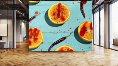 Orange halves with chili pepper powder and chamoy on turquoise background Wall mural