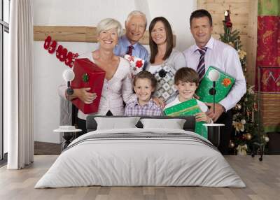 Grandparents, parents and children holding Christmas presents Wall mural