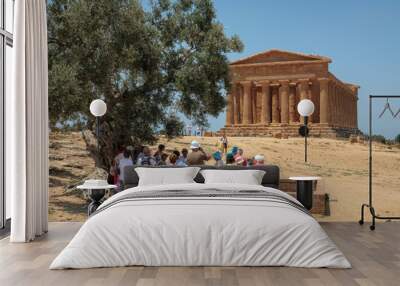 Agrigento. Valle dei Templi. Tempio della Concordia with group of visitors on the background of centennial' olive Wall mural