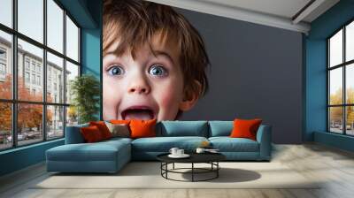 A six year old boy child is being funny and making a bratty face while sticking out his tongue. Copy space image. Place for adding text or design Wall mural