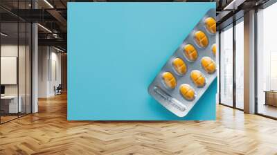 Blister pack of pills on blue backdrop with copy space image; symbolizing pharmacy and medicine. Wall mural