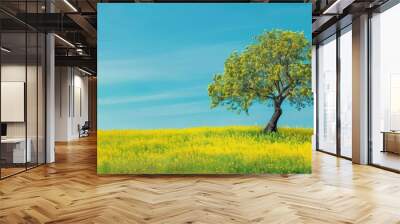 Colorful spring landscape featuring blooming rapeseed fields and a tree set against a vivid blue sky providing a picturesque natural backdrop with ample copy space for an image Wall mural