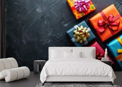 Gift boxes with colorful ribbons on black background seen from above providing copy space image Wall mural