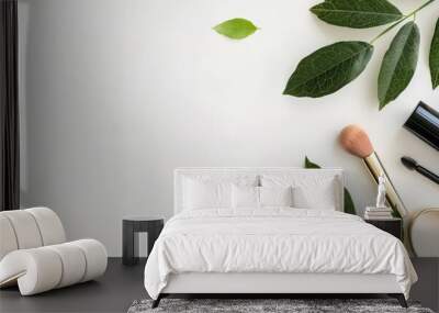 Minimalistic flat lay composition featuring cosmetic and nature elements, including a makeup bottle and a leaf, against a white background with copy space image. Wall mural