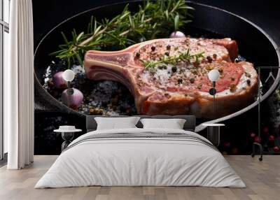 Raw Pork chops on flying pan ready to cook with herb salt pepper with wooden flipper on dark background. copy space available Wall mural