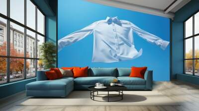 Clean shirt floating on a blue sky background Wall mural