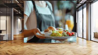 Closeup waitress in uniform holding a tray with food in a hotel or restaurant hall Wall mural