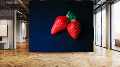 Two delicious strawberrys on black background Wall mural