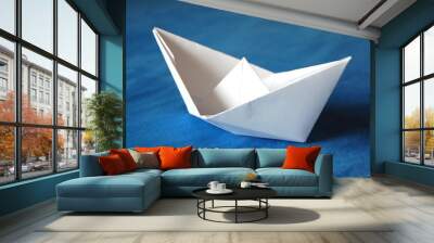 origami paper boat isolated on blue water Wall mural