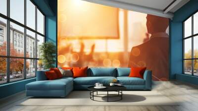 Back view of a businessman looking over a cityscape at sunset with an illuminated modern office background Wall mural