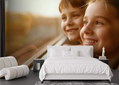 Two happy siblings are smiling while looking out the train window during a journey Wall mural