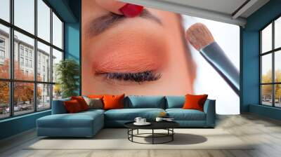 Makeup professional artist applying base color eyeshadow on model eye Wall mural