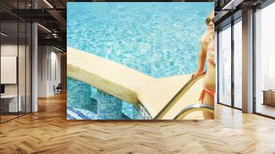 Children blond girl in swimming pool. Summer vacations. Wall mural