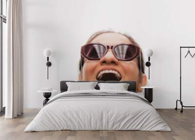 Woman with a surprised face looks up and reflects the lights from the ceiling in her glasses. Wall mural