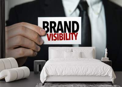 Business man holding a card with the text: Brand Visibility Wall mural