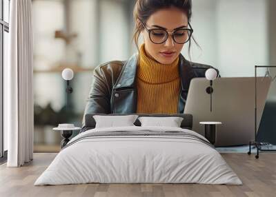 A business woman focuses on her work in a modern office environment, typing on her laptop with concentration Wall mural