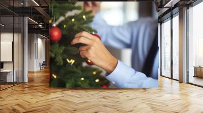 Business man decorating christmas tree at office Wall mural