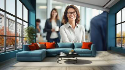 Happy mid aged business woman manager handshaking at office meeting. Smiling female hr hiring recruit at job interview, bank or insurance agent, lawyer making contract deal with client at work. Wall mural