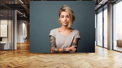 Young blond pretty girl beauty female model with short blonde hair beautiful face healthy skin and tattoos looking at camera isolated at gray background. Close up headshot portrait. Wall mural