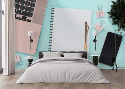 Blank notebook next to laptop, smartphone, pen, beautiful aloe vera and paper clips Wall mural