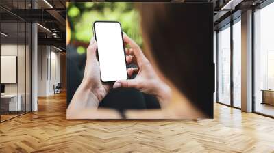 Girl using smartphone blank screen frameless modern design while lying on the sofa in garden Wall mural