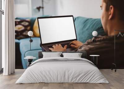 Man using laptop blank screen while sitting on sofa  Wall mural