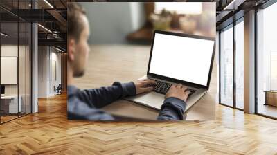 man using notebook with blank screen in home interior. Wall mural